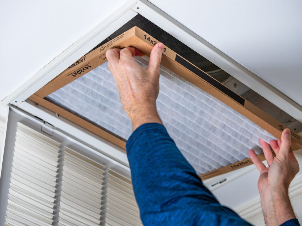 HVAC technician replacing a home air filter in La Puente