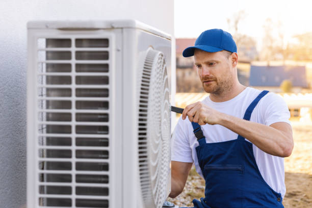 HVAC technician servicing an outdoor air conditioner in La Puente